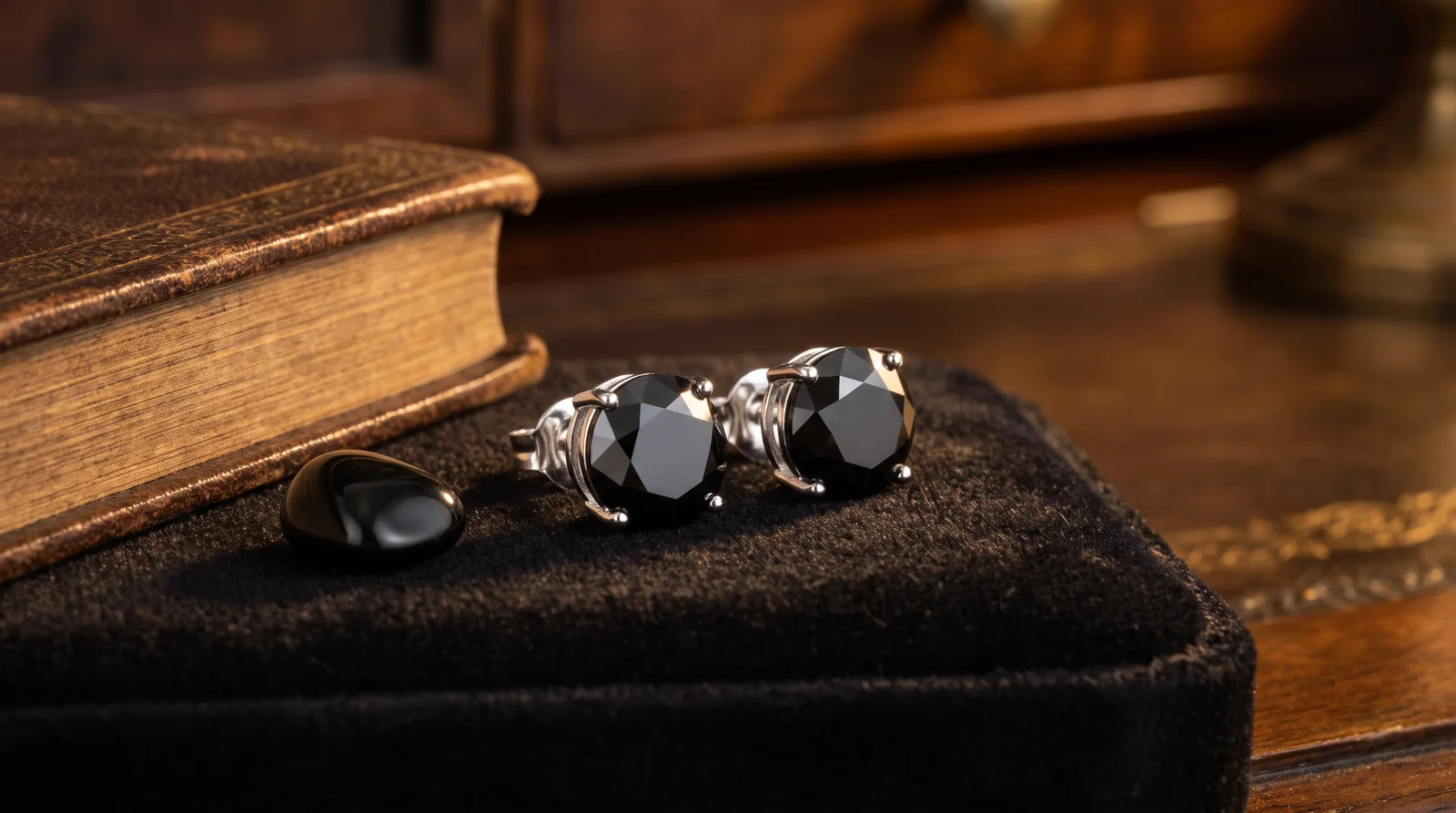 Black diamond earrings symbolizing strength and mystery, displayed elegantly against a dark background