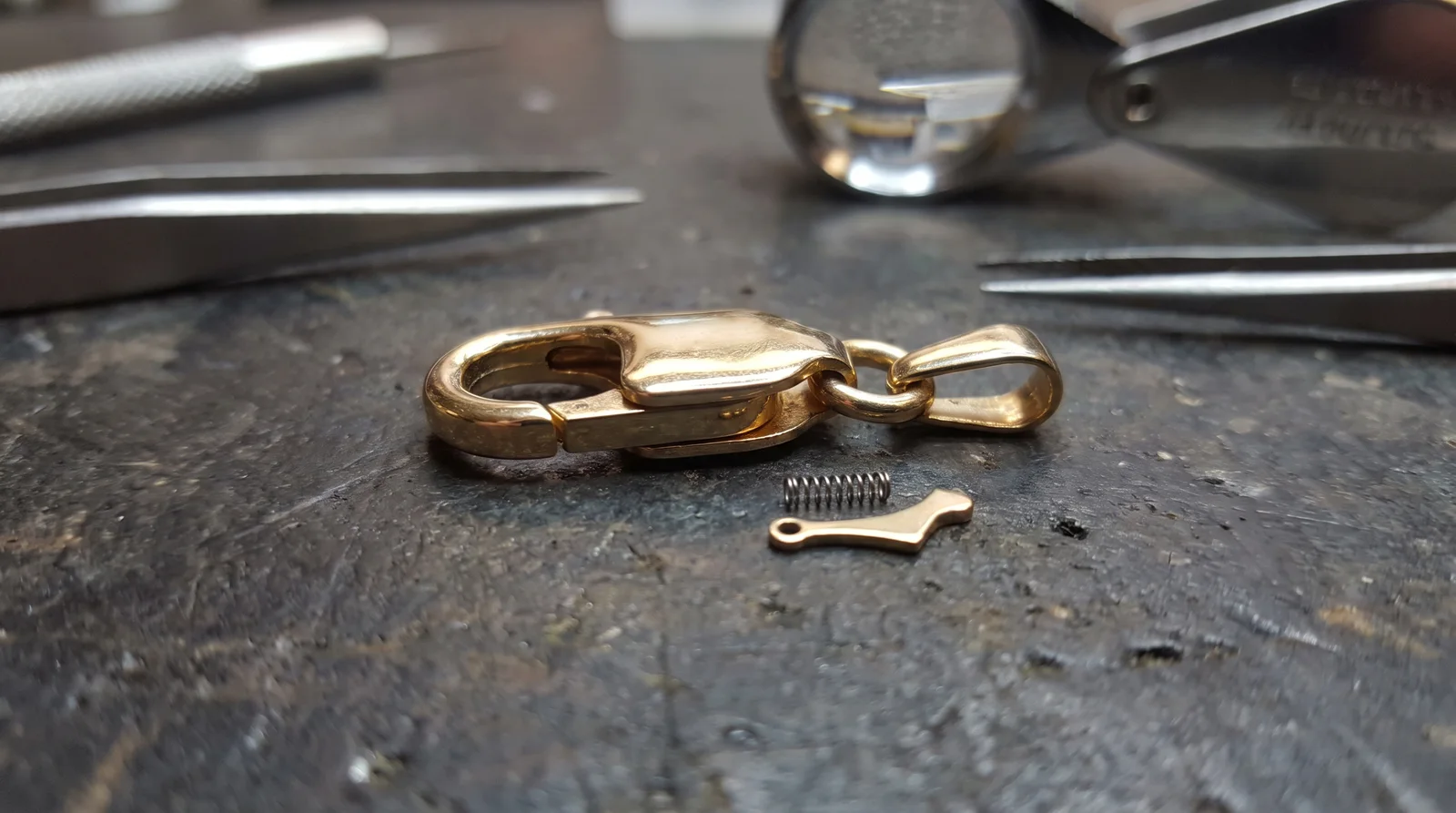 Close-up of a lobster clasp mechanism showing spring lever, illustrating why a lobster clasp won't close properly