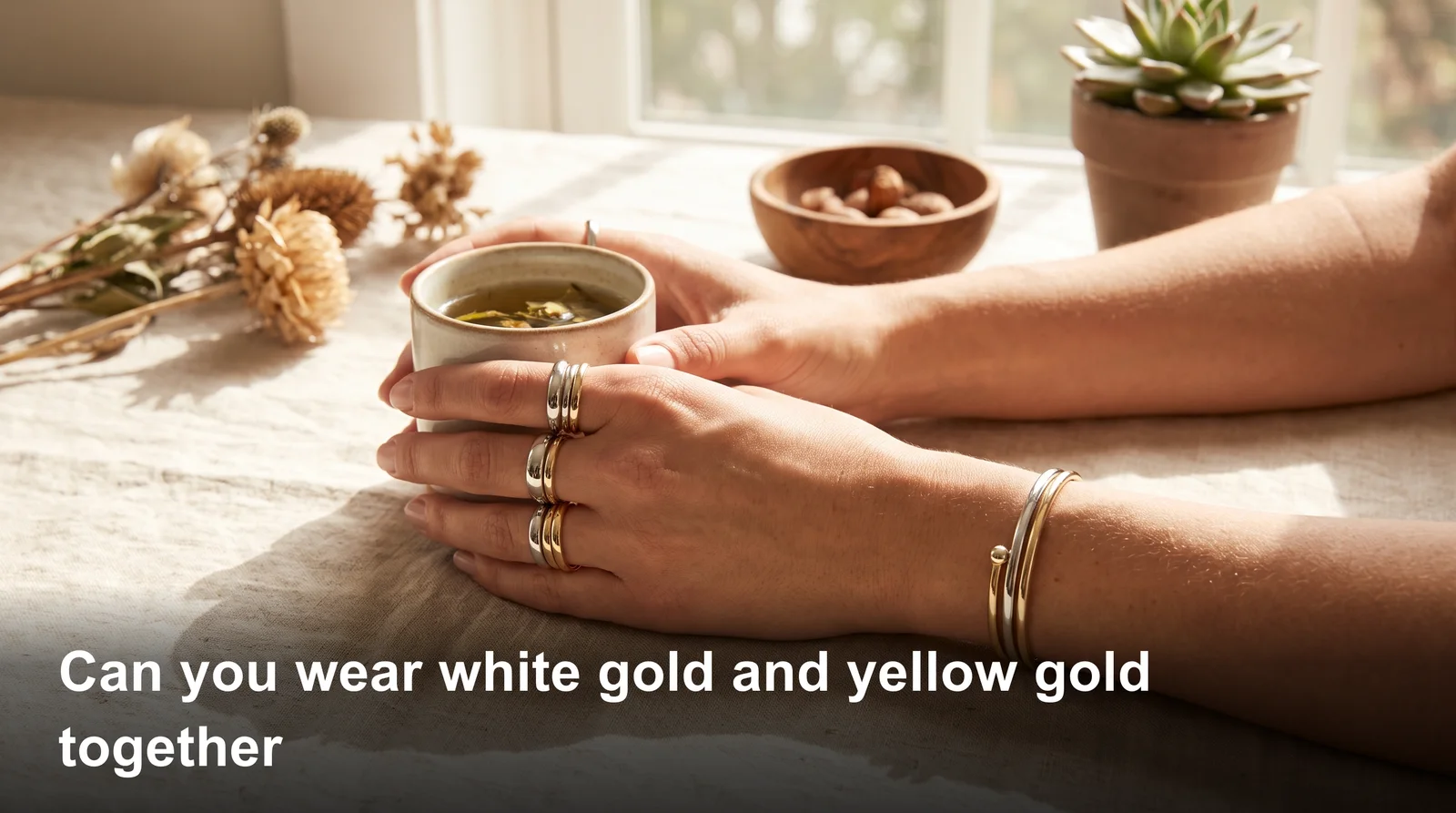 Woman wearing stacked white gold and yellow gold rings together, showing mixed metal jewelry style