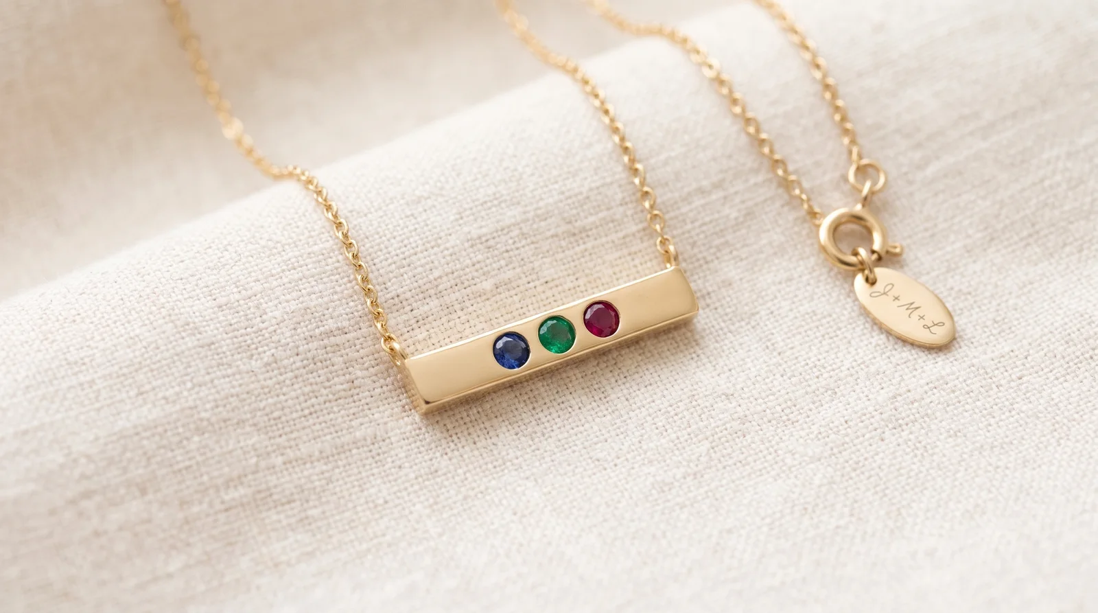 Engraved family birthstone necklace with subtle personalized script on a delicate gold pendant chain