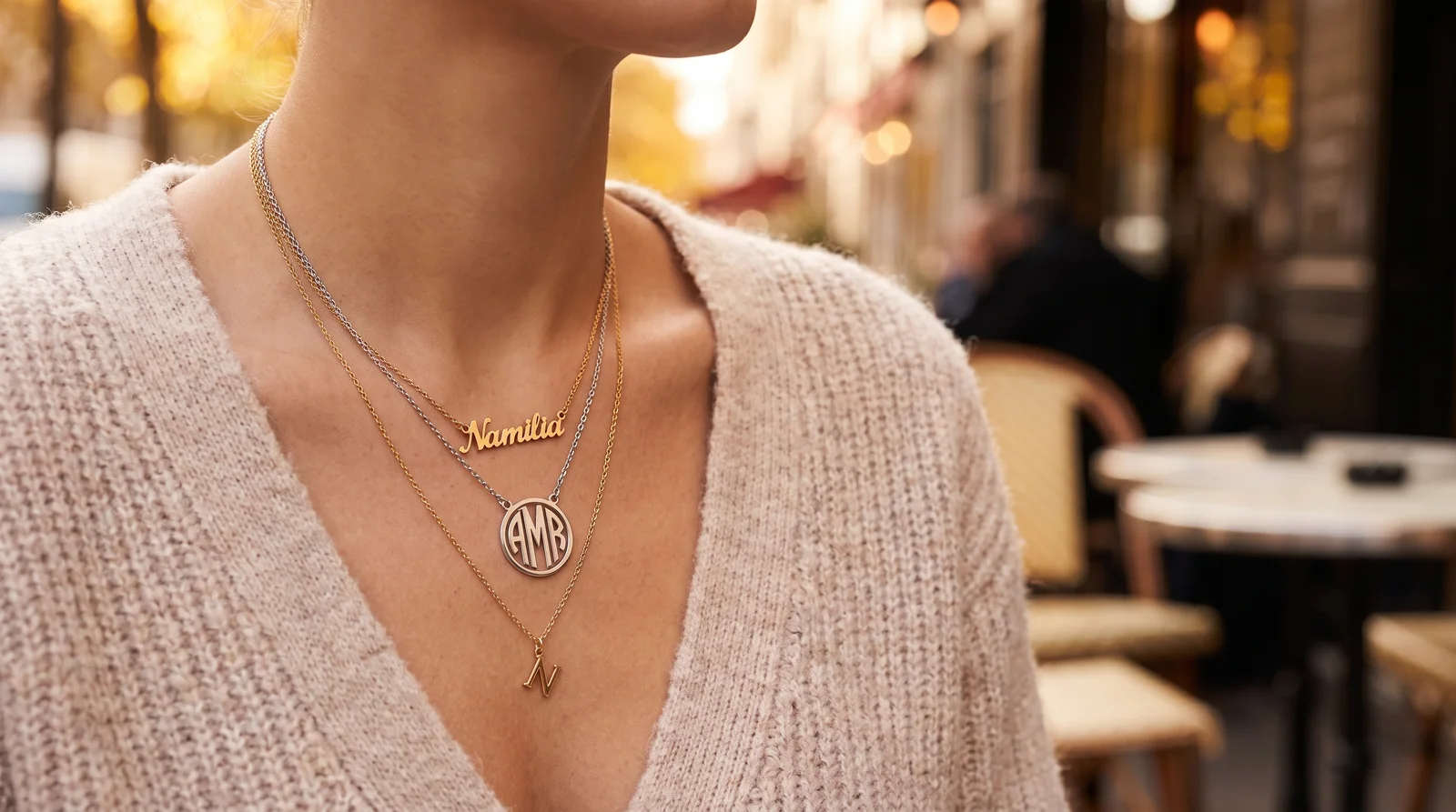 Layered gold necklaces comparing initial necklace vs name necklace styles with monogram and single letter pendants