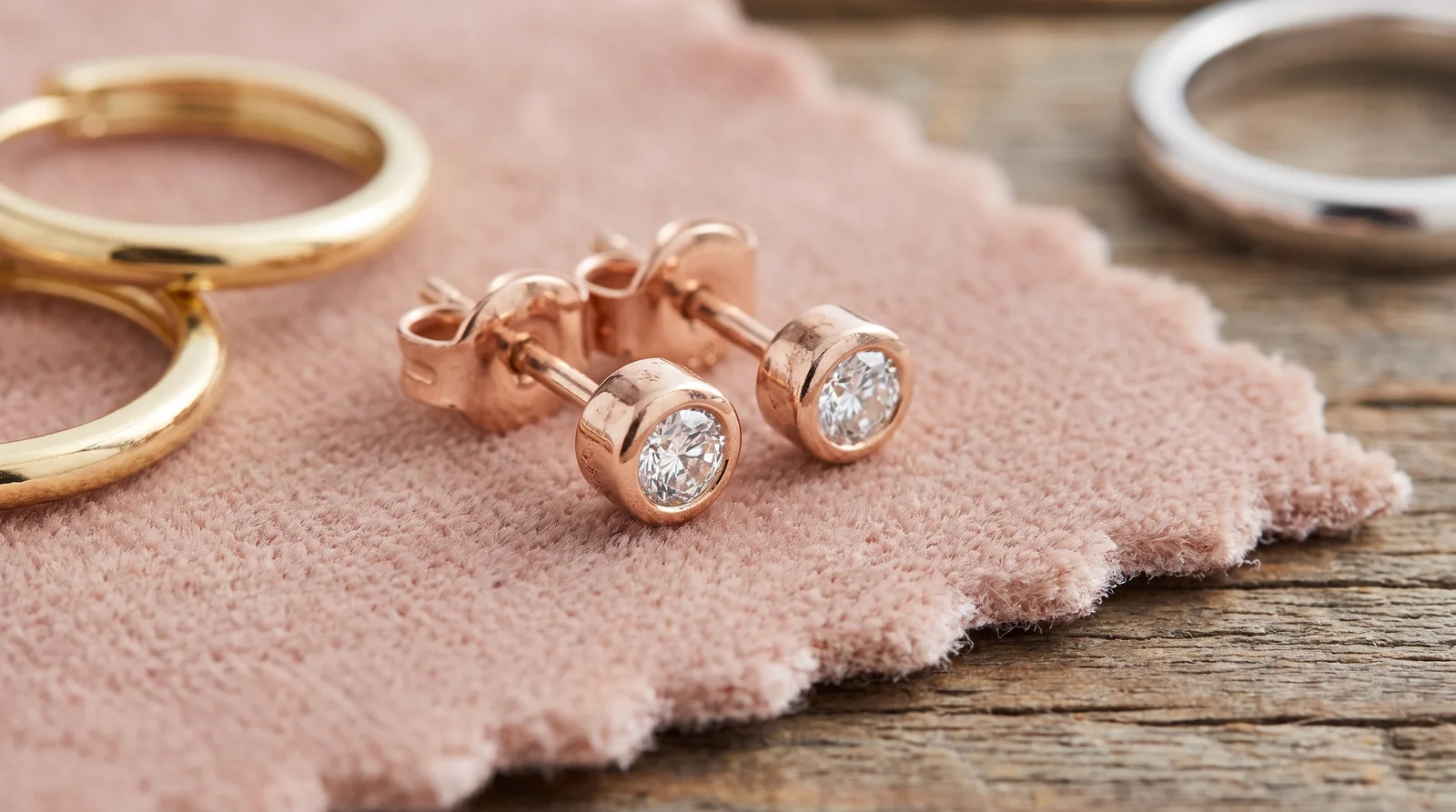 Rose gold and white gold diamond studs side by side, illustrating color and tarnish characteristics over time