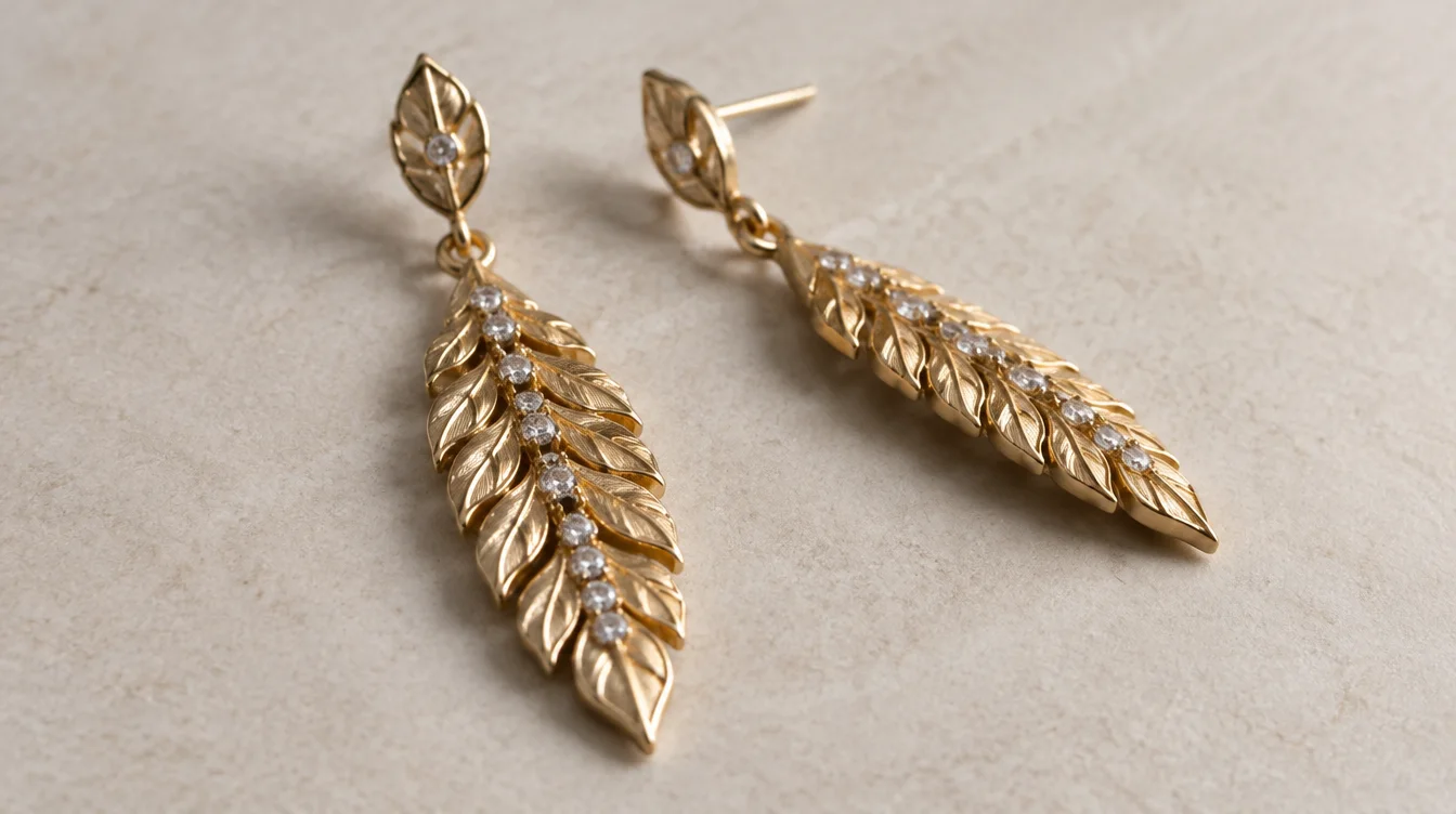 Rigid leaf drop earrings showing continuous relief and stone settings with no separate decorative sections