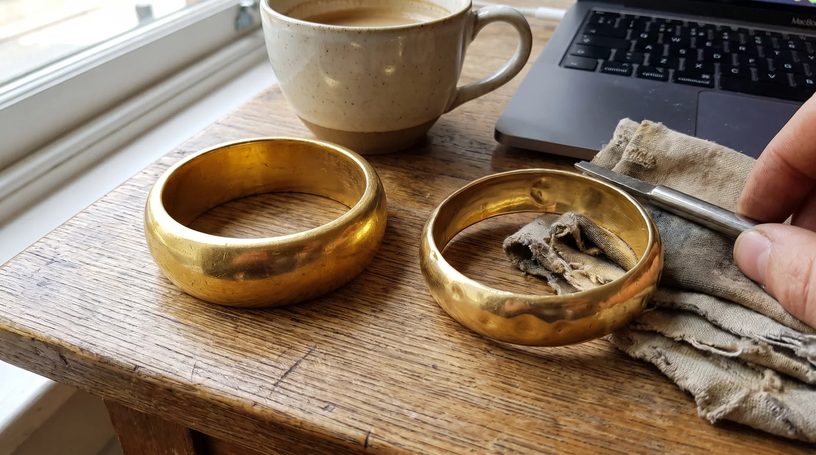 Solid gold bangle next to hollow gold bangle demonstrating structural durability under daily wear