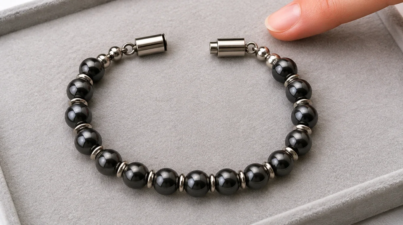 Open bead bracelet showing clasp halves, connecting loops, and spacers on a padded surface